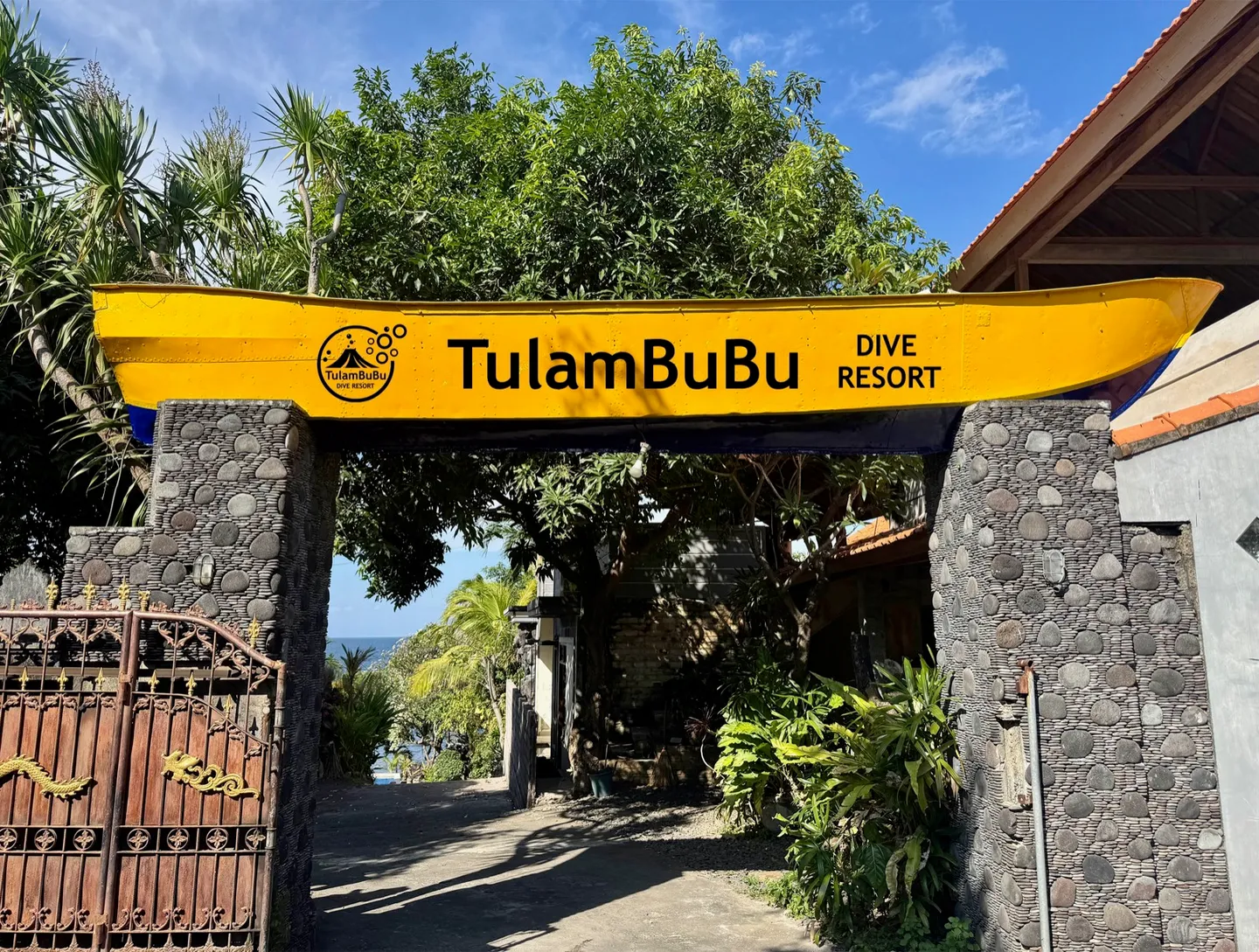 Tulambubu Dive Resort 入口招牌，黃色船型看板搭配可愛 Logo